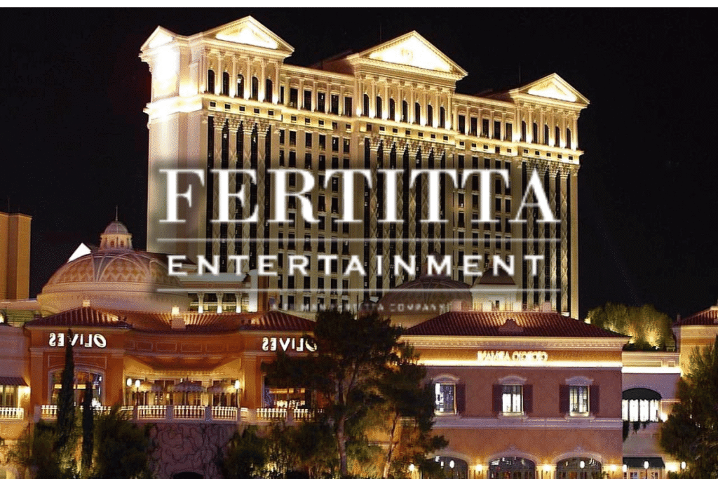 Fertitta Caesars $17.6B merger reshapes national casino industry Fertitta Entertainment logo displayed over Caesars Palace Las Vegas after proposed $17.6 billion Caesars Entertainment acquisition announcement.