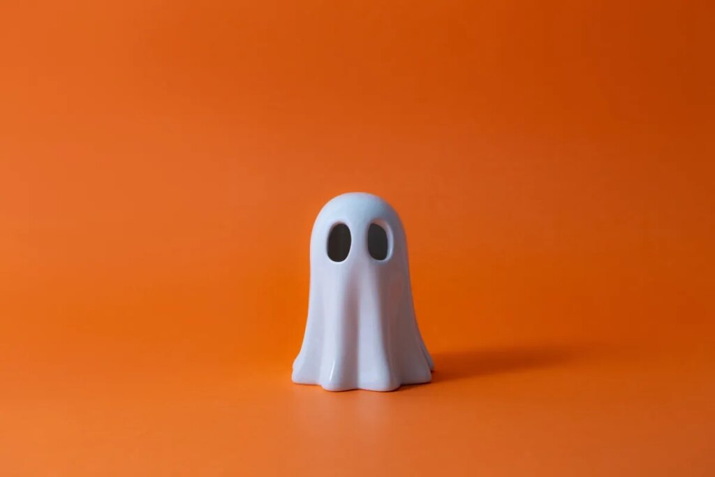 Snap alums unveil Ghost Angels fund Cute Halloween Ghost over orange background.