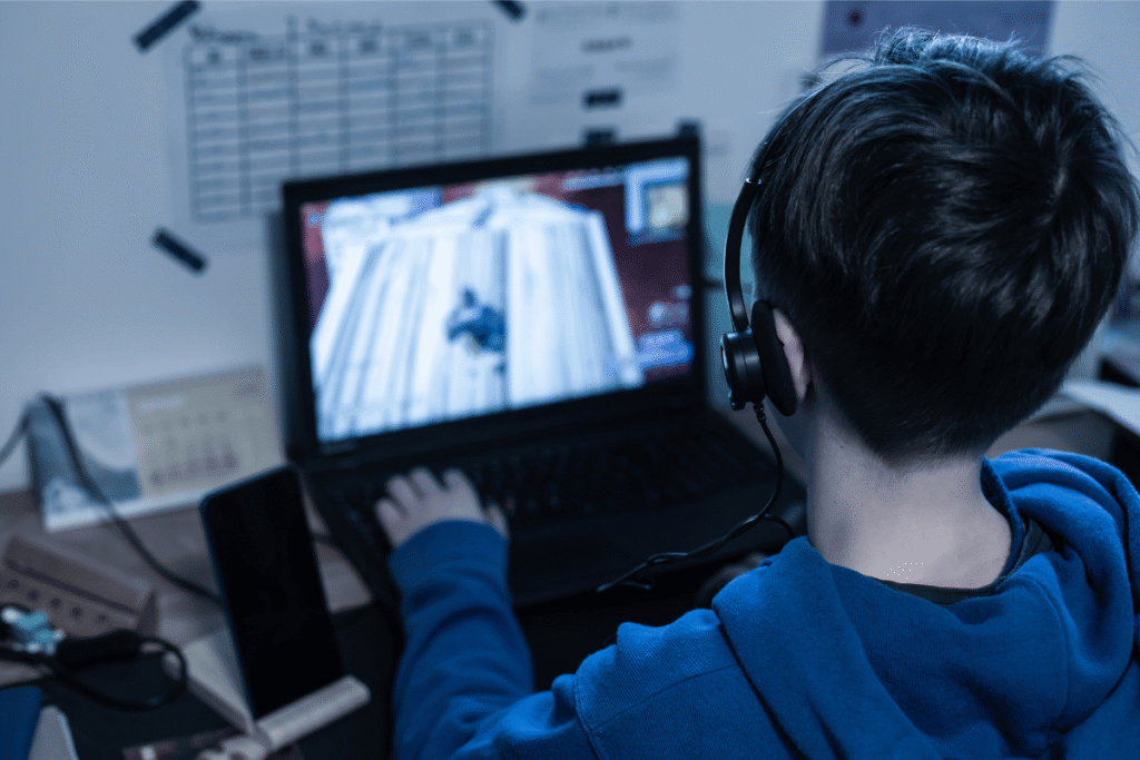 Teen sues Roblox and others over ‘addictive’ gaming design Teen playing Roblox-style online video game on laptop wearing headset amid lawsuit concerns over addictive gaming and microtransactions
