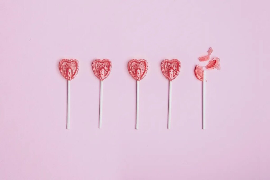 Almost half of U.S. singles feel negatively about AI in dating, Match says Five lollipop hearts on a pink floor, but the last one is smashed to pieces.