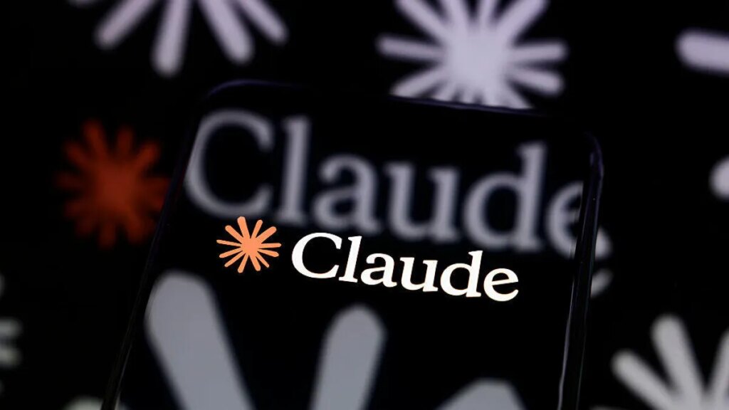 Anthropic’s Claude Fable 5 Is the First Mythos-Level AI Model You Can Actually Use The Claude logo is displayed on a smartphone screen placed on a reflective surface onto which a multitude of Claude logos are projected
