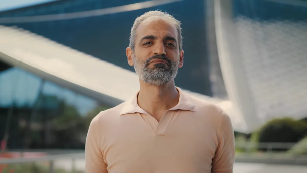 middle-aged man with peach collar shirt and gray beard