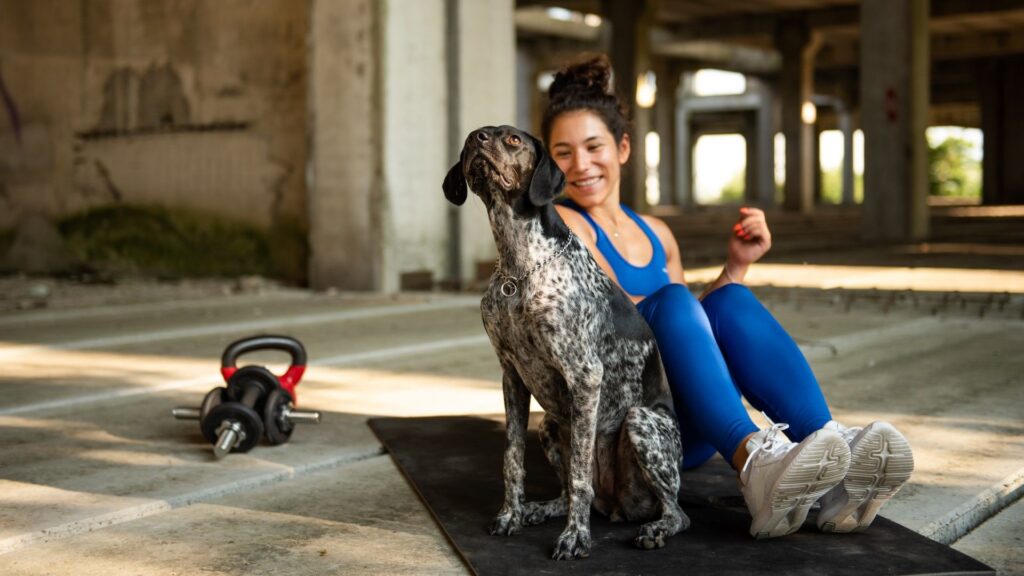 I tried this 3-move mobility routine using my dog instead of dumbbells. Here’s what happened Woman sitting on an exercise mat with her dog during workout