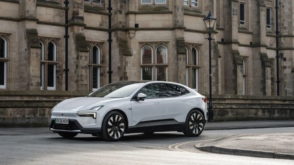 Polestar Faces a Ban on Selling Its EVs in the US A white Polestar 4 vehicle is parked next to a building on a curved roadway.