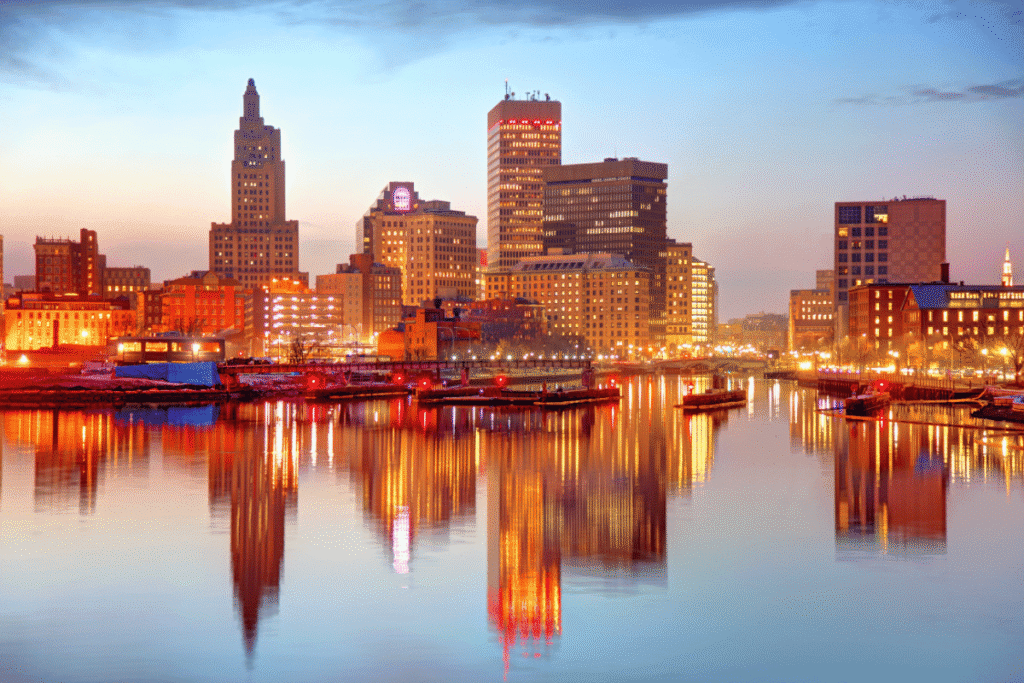 Rhode Island Senate approves sports betting market expansion Rhode Island skyline at sunset reflected on the Providence River, highlighting downtown Providence as lawmakers consider expanding the state's sports betting market and ending its sportsbook monopoly.
