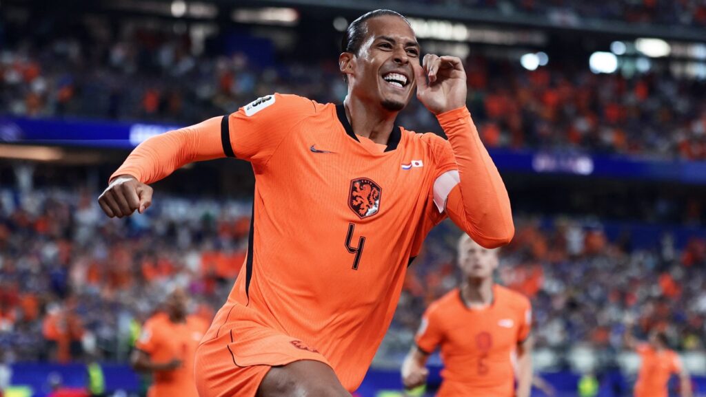 Netherlands' defender Virgil van Dijk, wearing orange, touches his ear in celebration after scoring the opening goal during the 2026 World Cup Group F match with Japan.