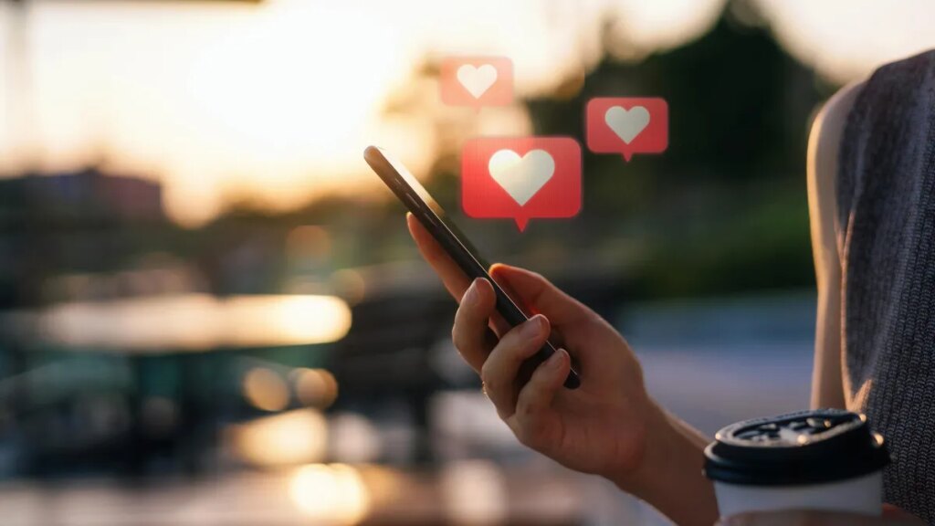 White hearts coming from phone that person is holding.