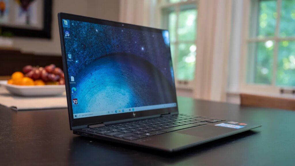 The HP Envy x360 13 from 2020 on a kitchen table with fruit and physical windows in the background