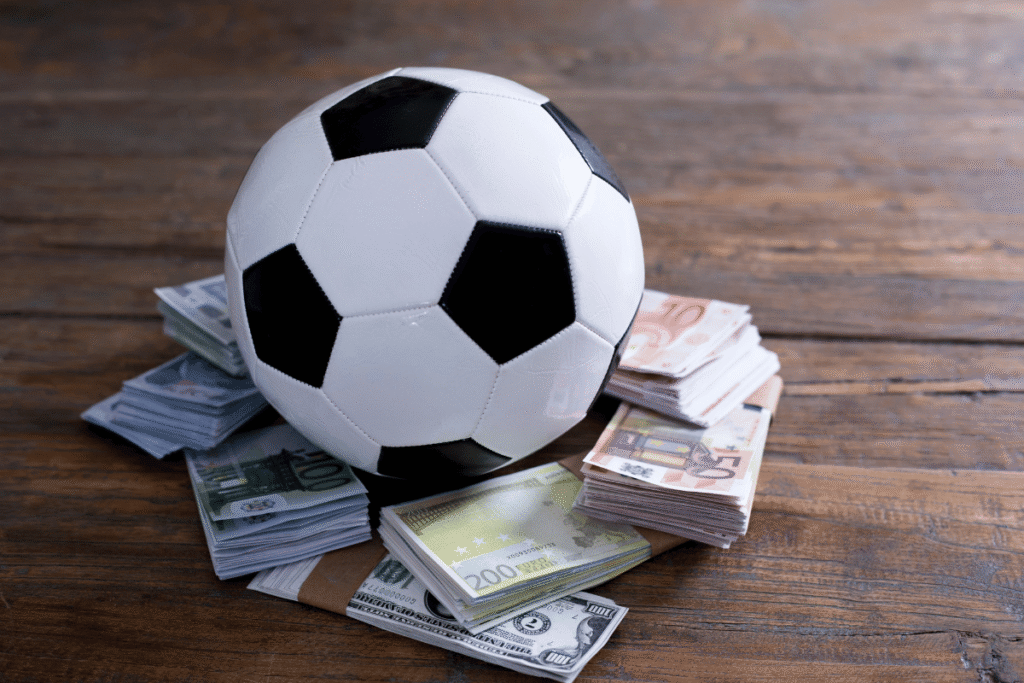 Norway match-fixing survey highlights reporting challenges globally Soccer ball resting on stacks of euro and U.S. dollar banknotes, illustrating sports betting, match-fixing, gambling integrity risks, and athlete betting regulations. Norway match-fixing survey shows sports manipulation reporting gaps amid global integrity concerns